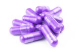 pile-proton-purple-color-organic-capsules-isolated-white-background-closeup-with-selective-focus_636705-2609
